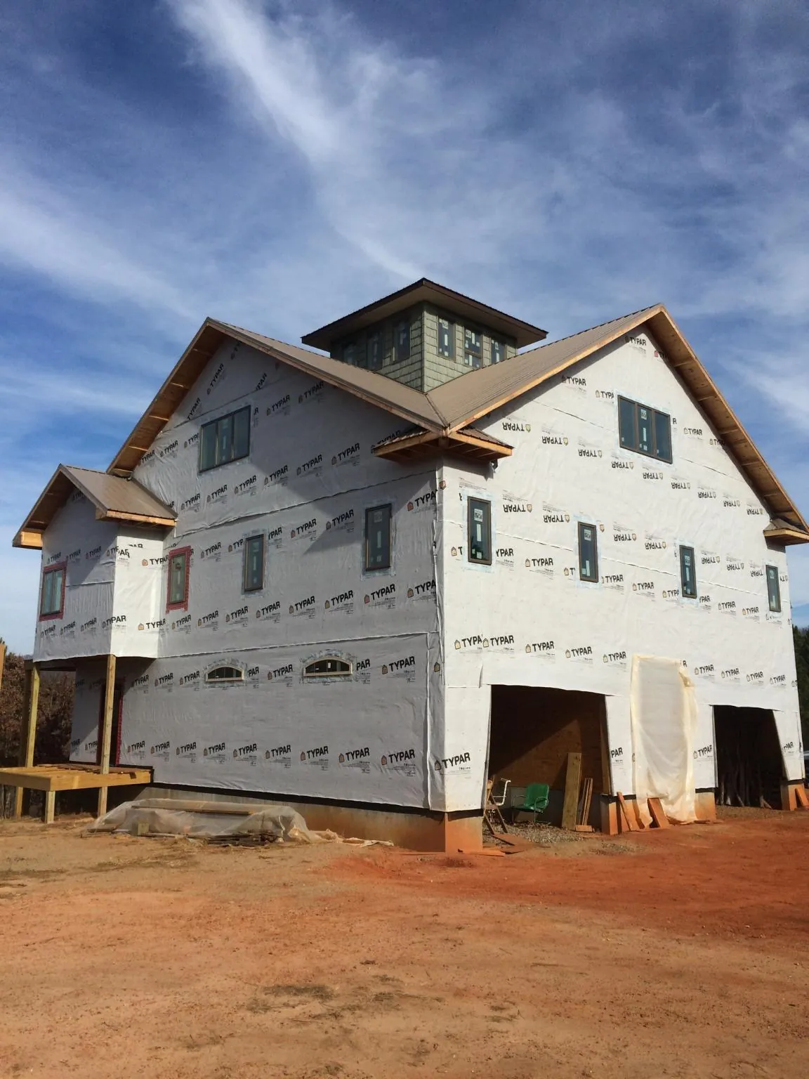 New two story house under construction with a cupola and gabled roofs in Loxley